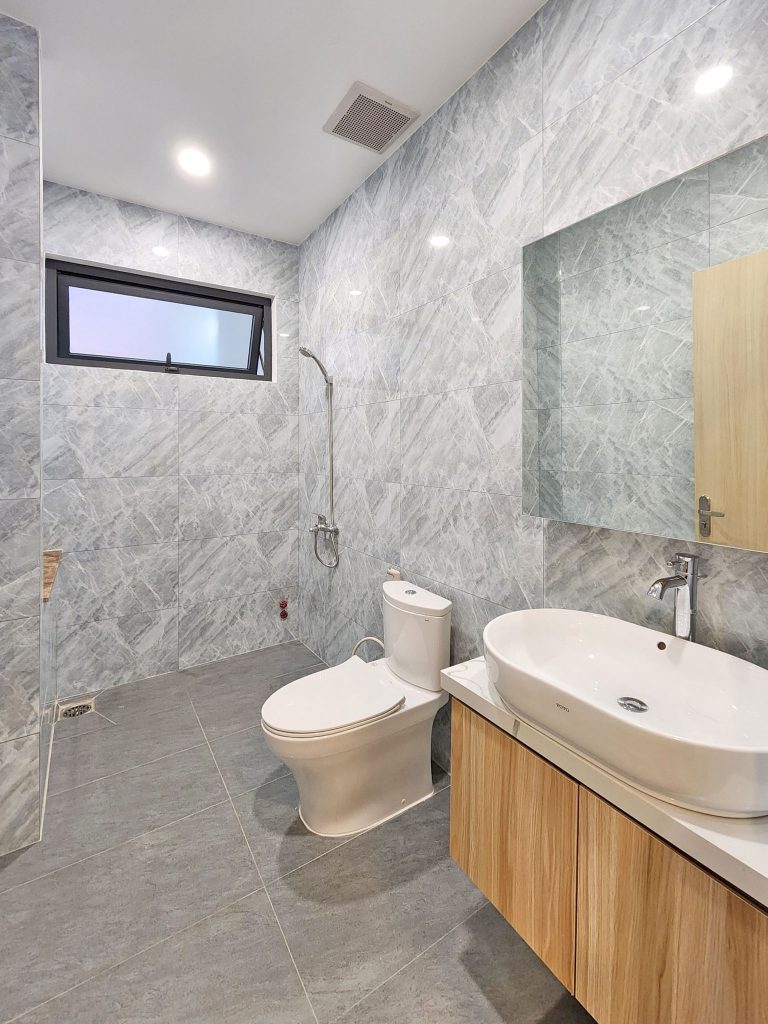 Phòng tắm thiết kế phối hợp các chất liệu gạch ốp vân mây khiến không gian có cảm giác thông thoáng, rộng rãi