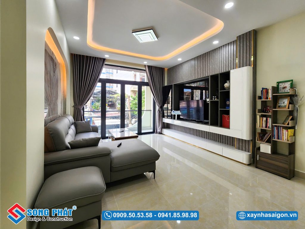 Không gian phòng khách ở tầng lửng được thiết kế rộng rãi với hệ cửa kính lớn mang lại không gian thoáng sáng