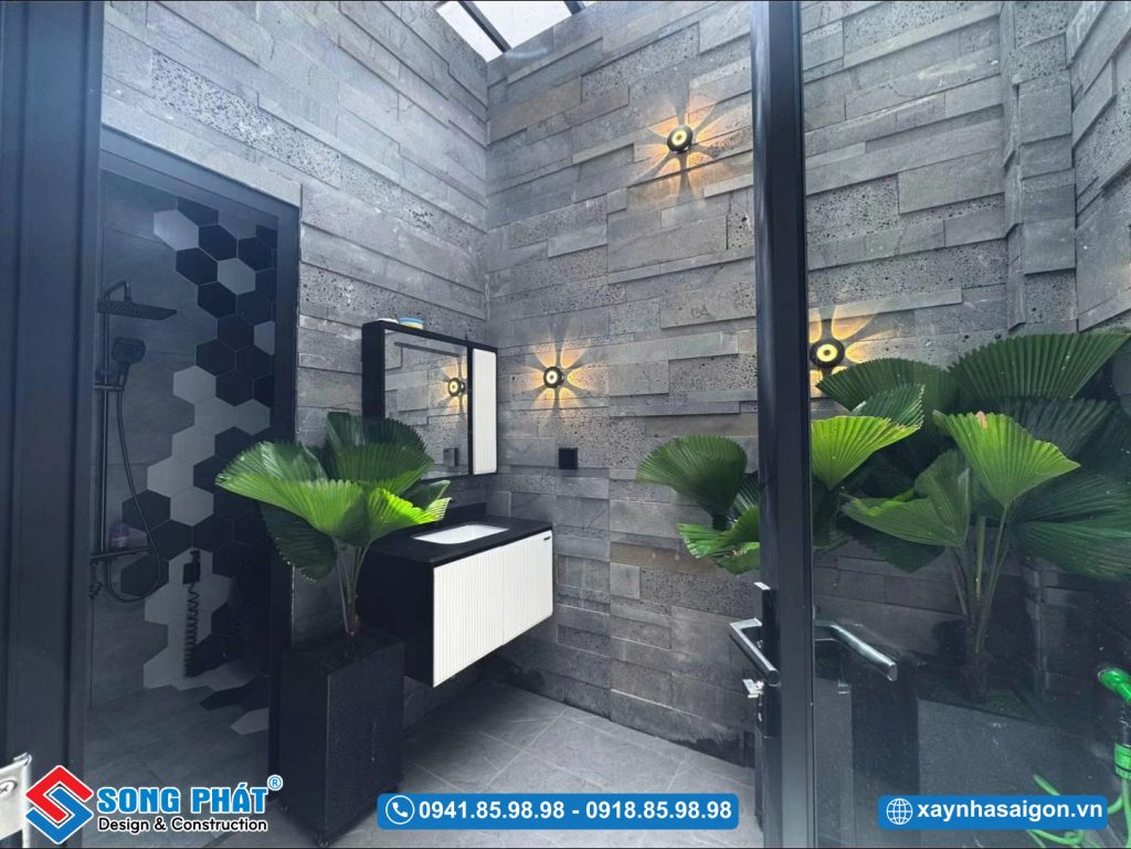 Khu vực lavabo nhà vệ sinh thoáng sáng nhờ giếng trời, điểm xuyết cây xanh tạo cảm giác thư giãn
