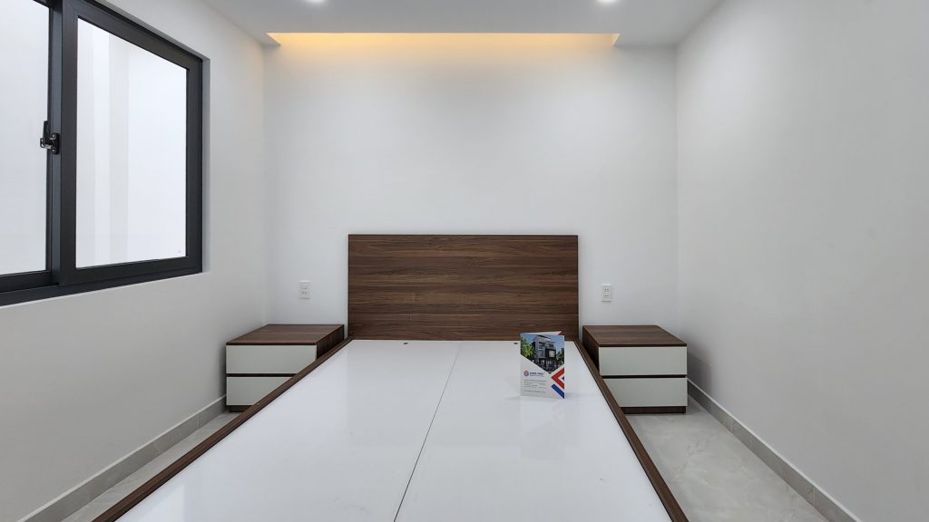 Phòng ngủ 1 với đồ nội thất gỗ đơn giản và gần gũi.
