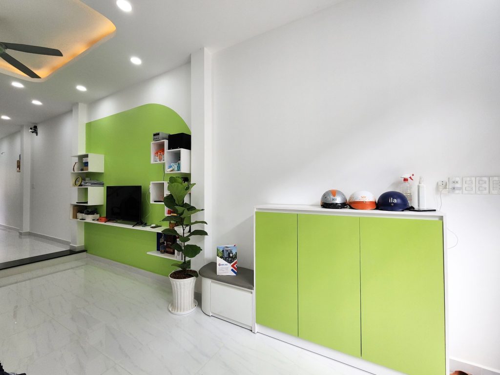 Phòng khách rộng rãi với nội thất màu xanh lá mát mẻ, bắt mắt. 