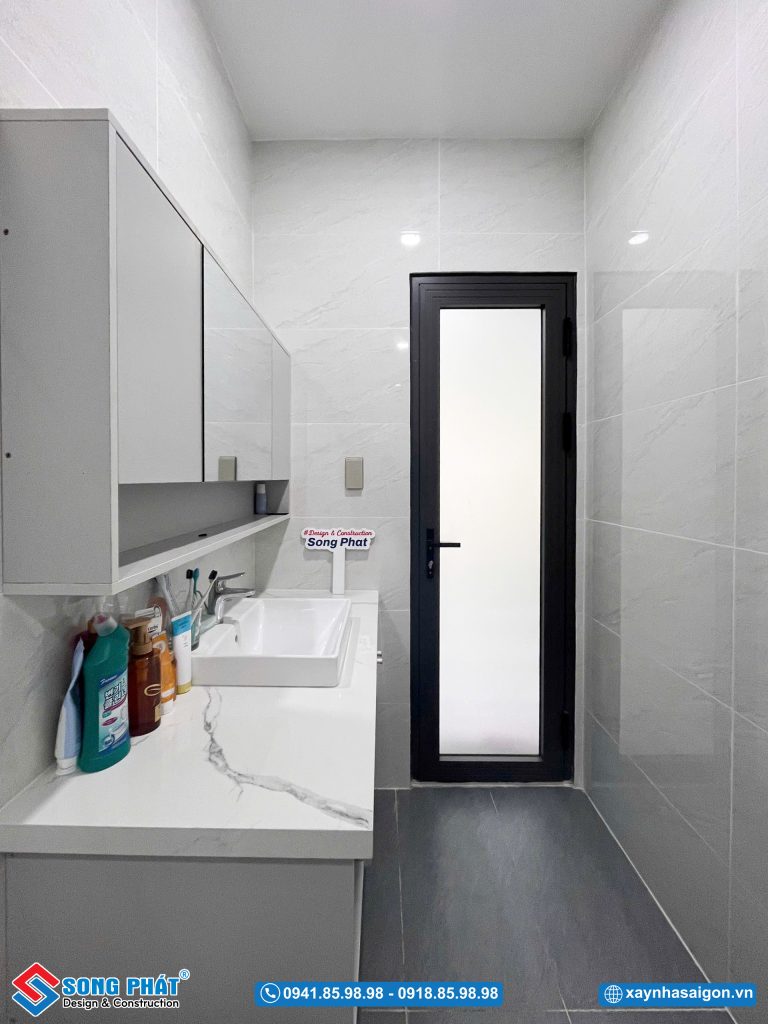 WC với hệ tủ kính rộng, tạo không gian đựng vật dụng thẩm mỹ