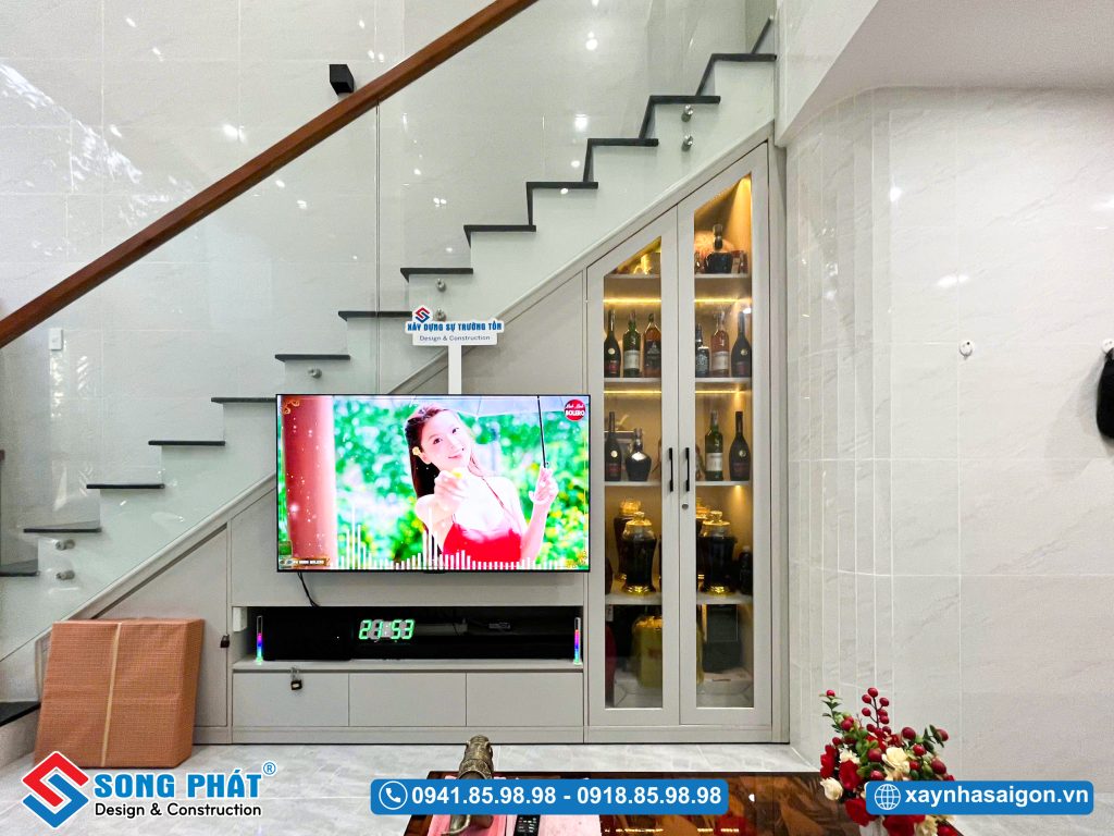 Chân cầu thang được tận dụng làm khu vực TV và tủ trang trí