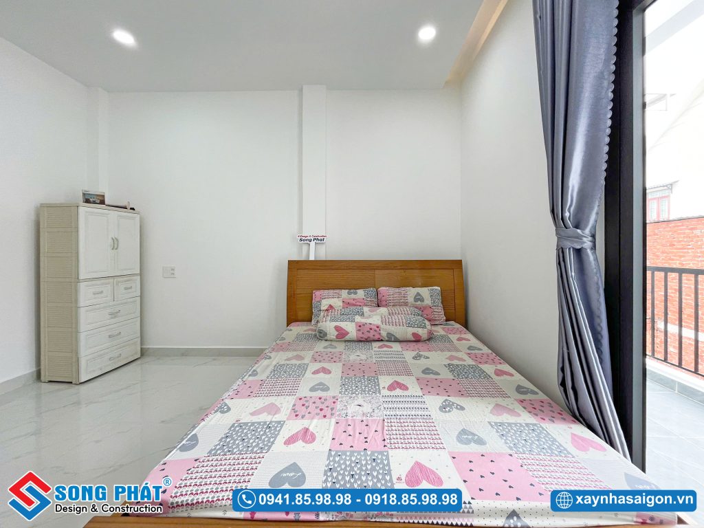 Phòng ngủ ba mẹ được thiết kế tinh gọn với lối ra ban công thoáng đạt