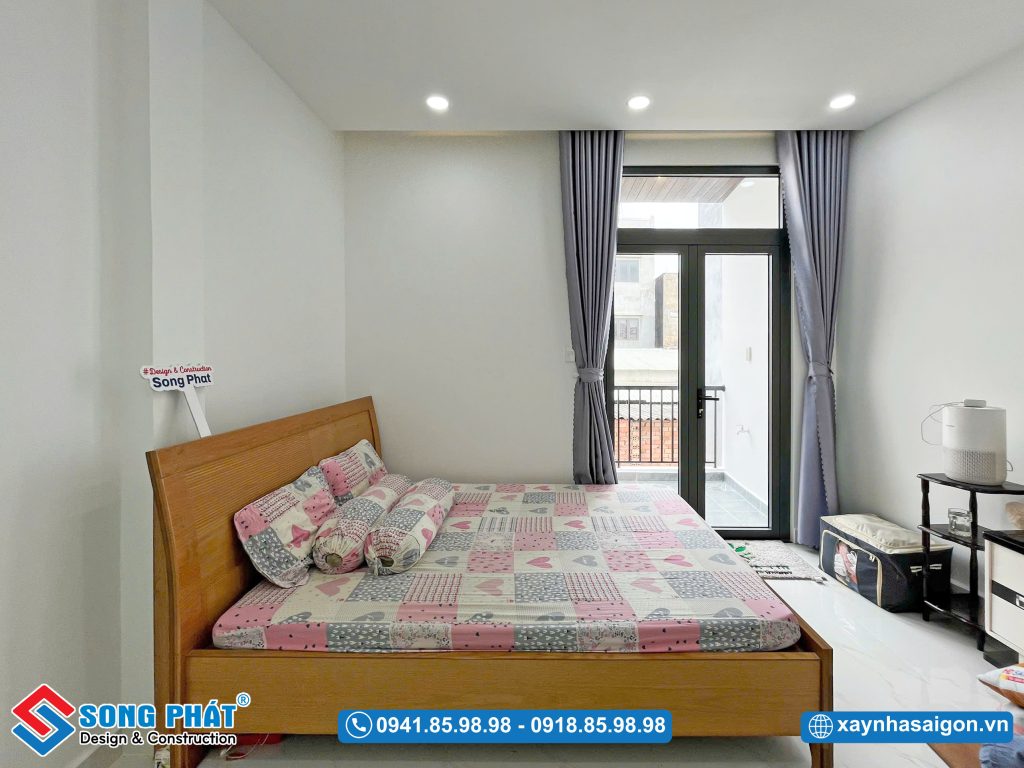Phòng ngủ ba mẹ được thiết kế tinh gọn với lối ra ban công thoáng đạt