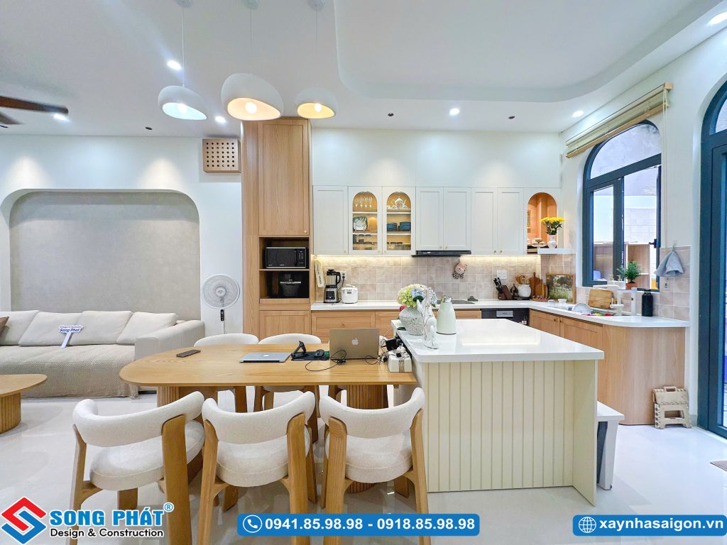 Bố trí bàn ăn gỗ liền kề đảo bếp tiện lợi.