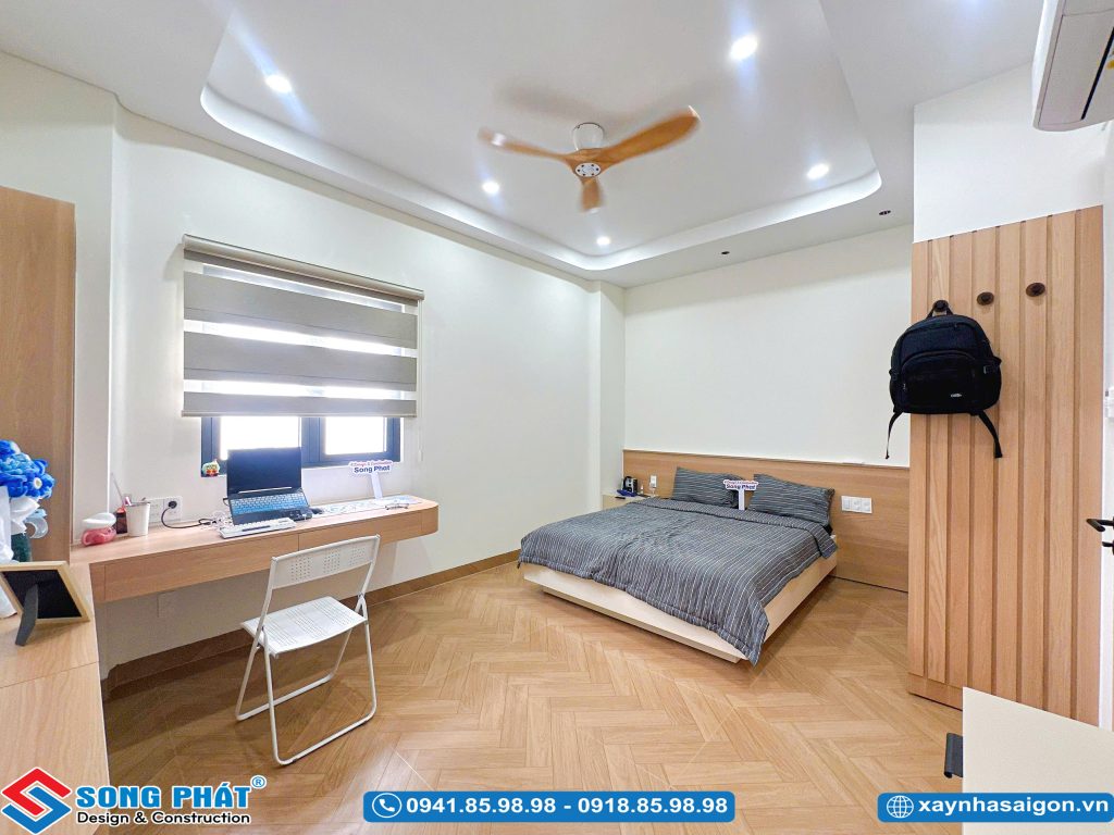 Phòng ngủ thoáng mát với bàn học cạnh cửa sổ.
