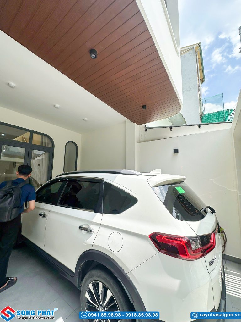 Sân trước đỗ xe ô tô với trần ốp gỗ nhựa sang trọng.