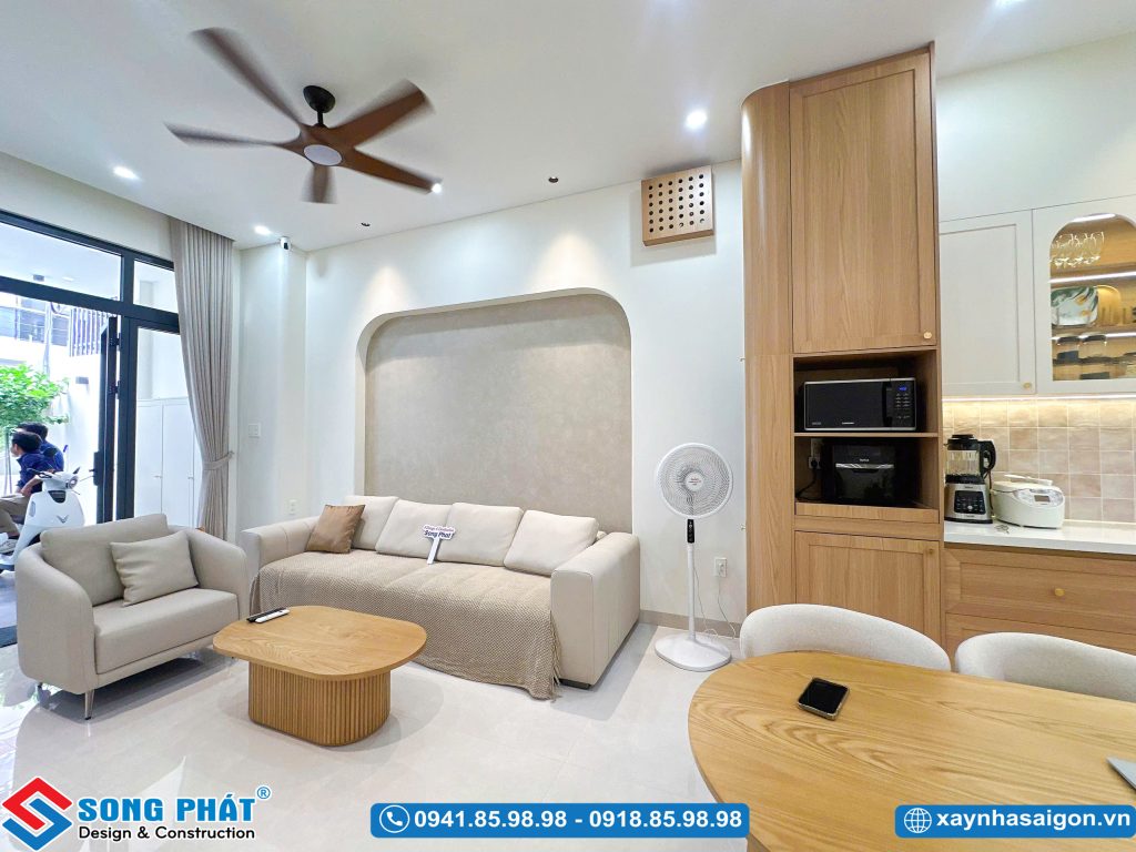 Bộ sofa màu kem mịn màng cùng bàn trà gỗ hình oval.