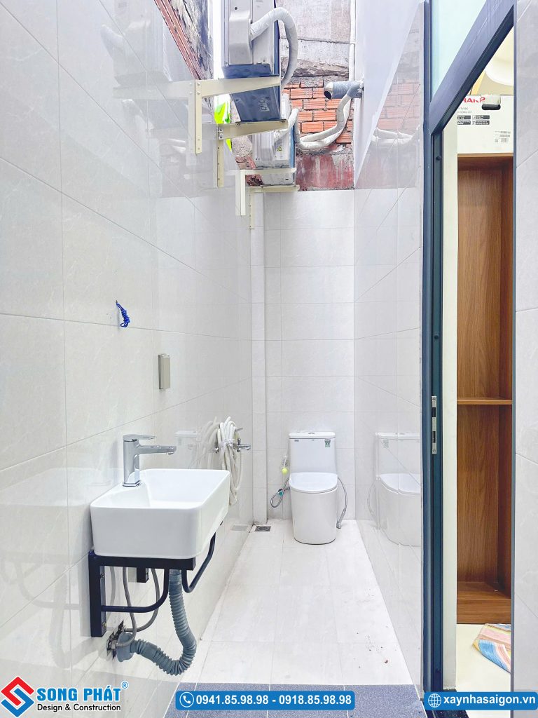 Khu vực sân sau thông thoáng được ốp gạch men sạch sẽ, lắp đặt chậu rửa và bố trí cục nóng máy lạnh.