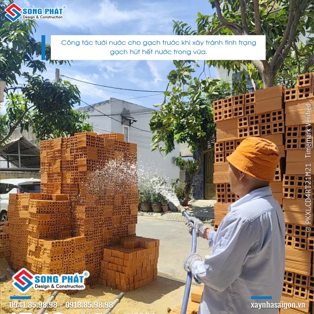 Công tác tưới gạch trước khi xây tường.