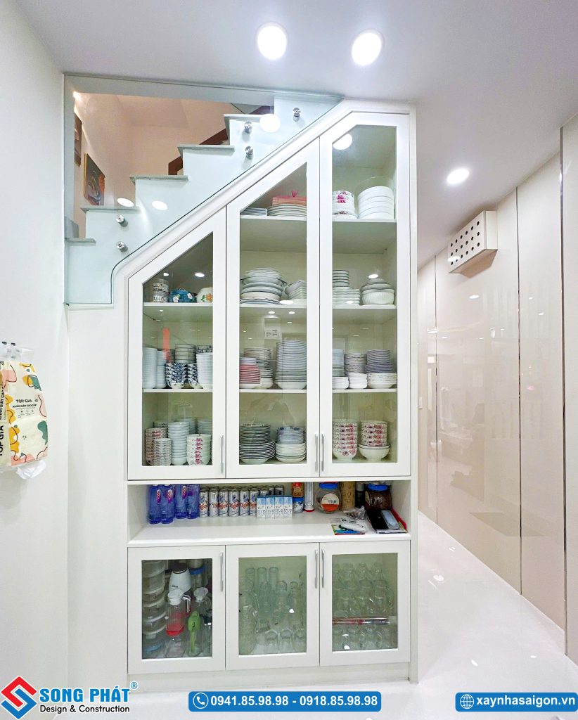 Tủ kính trưng bày chén dĩa âm tường gọn gàng dưới gầm cầu thang.
