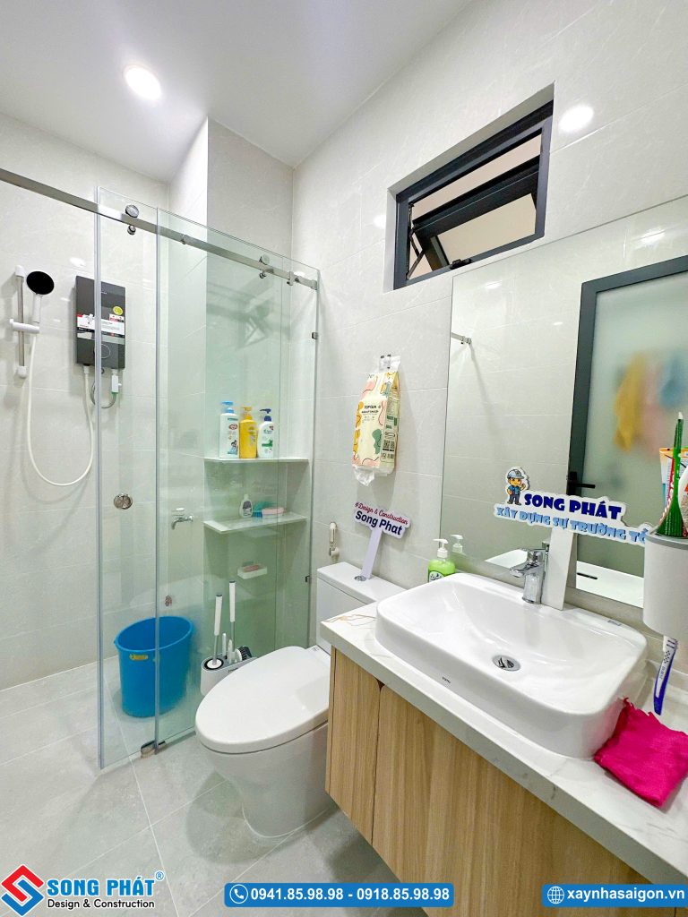 Phòng vệ sinh hiện đại có vách kính tắm đứng và thiết bị vệ sinh cao cấp.