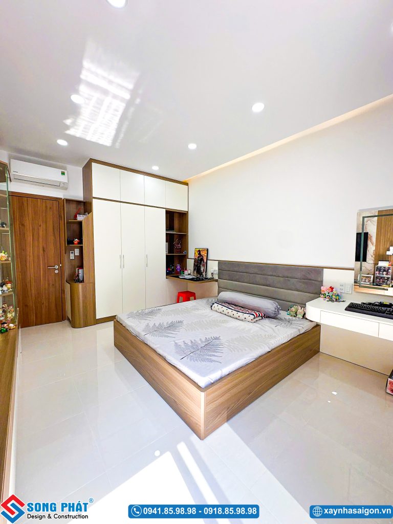 Tổng quan bố trí giường ngủ, bàn làm việc và bàn trang điểm trong phòng.