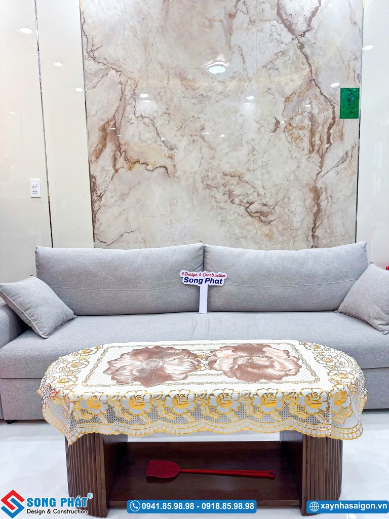 Bộ ghế sofa màu xám trang nhã cùng vách ốp tường vân đá sang trọng.