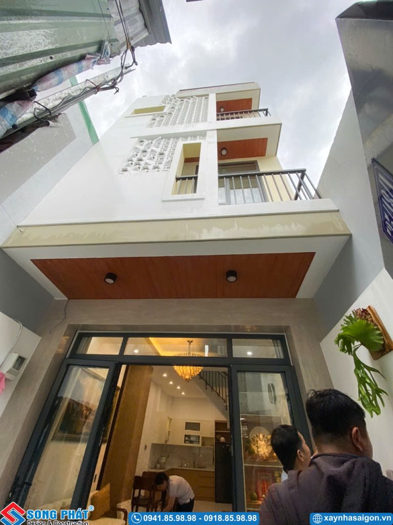Tổng thể mặt tiền nhà phố với hệ trần ốp gỗ và cửa kính cường lực.