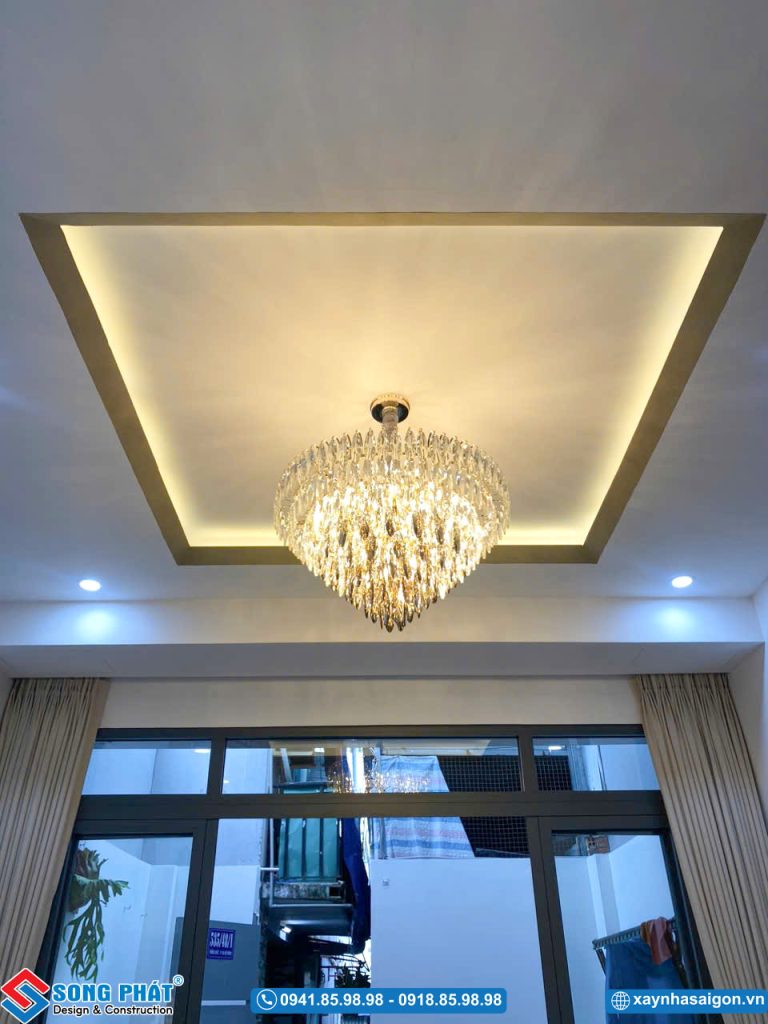 Chi tiết trần thạch cao giật cấp kết hợp đèn chùm trang trí tại phòng khách.