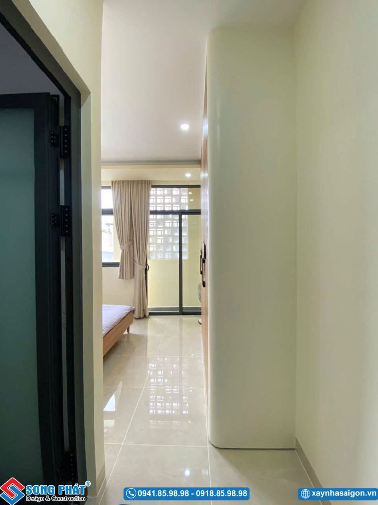 Hành lang nhỏ dẫn vào phòng ngủ với thiết kế tường và tủ âm tường gọn gàng.